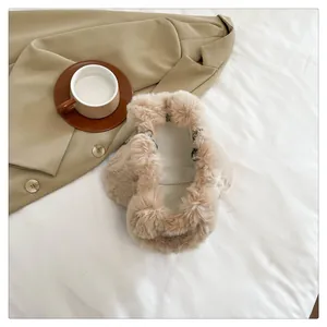Detailed view of beige fluffy plush handbag with soft faux fur texture and silver hardware