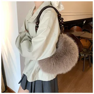 Detail of light brown plush crescent bag with decorative dark wooden beaded handle
