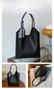 Detail of black lychee grain tote bag featuring a decorative checkered silk scarf and logo