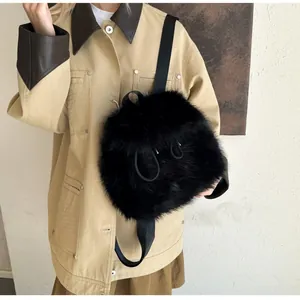 Detail of black faux fur plush backpack featuring round silhouette and metal ring accents