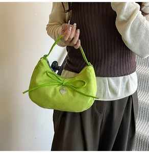 Détail du sac fourre-tout croissant vert fluo avec nœud et breloque cœur en situation réelle