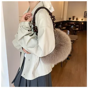 Detail of taupe faux fur handbag with dark beaded wood handle and soft plush texture