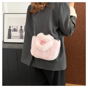 Detail of pink faux fur crossbody bag with silver metal chain strap on model shoulder