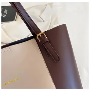 Detail of contrast stitch large tote bag with gold buckle and fashion lettering