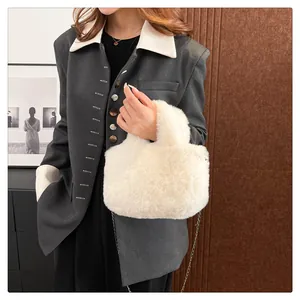Chic cream faux fur crossbody bag with elegant metal chain strap on model's shoulder
