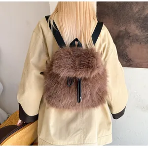 Detail of plush brown faux fur backpack featuring black drawstring and durable straps