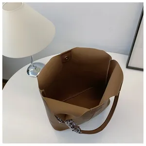 Top view of brown tote bag with pebble leather, large interior, and braided handle detail