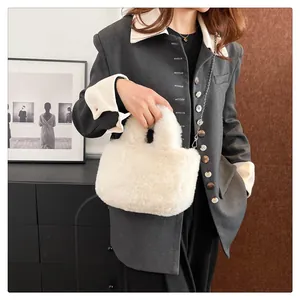 Close-up of off-white faux fur handbag with a metal chain strap on a model