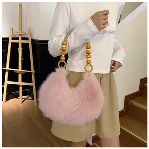 Detail of pink faux fur handbag featuring yellow wooden beaded handle and gold metal rings