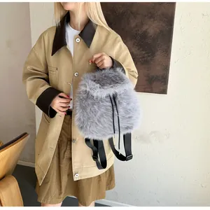 Grey faux fur backpack with drawstring closure worn with casual autumn outfit