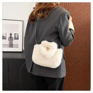 Detail showing plush faux fur texture and silver metal chain strap on a white bag