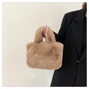 Detail of light brown faux fur handbag with plush handle held against black blazer