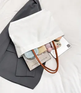 Detailed interior of large white canvas tote showing spacious storage for iPad and books