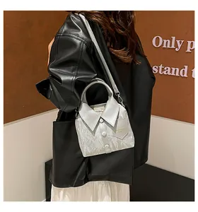 Detail of silver shirt-shaped crossbody bag featuring faux collar and button accents