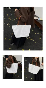 Three-way view of a large white canvas tote bag with brown leather straps in autumn