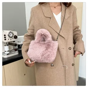 Detail of pink faux fur crossbody bag with metal chain strap and soft plush texture