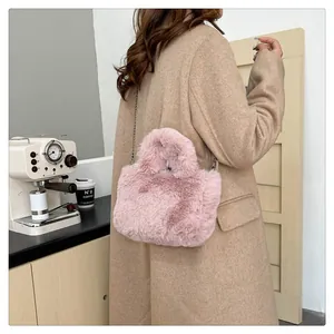 Back view of pink fluffy faux fur handbag paired with a beige winter coat