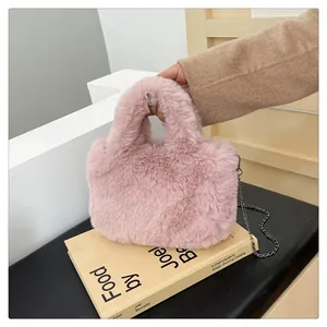 Detail of pink faux fur handbag showing soft plush texture and metallic chain strap