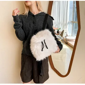 Close-up of white plush backpack with black drawstring and adjustable straps on a model
