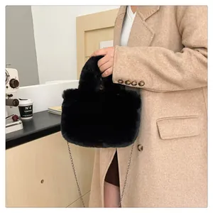 Detail of black faux fur handbag with soft plush texture and silver metal chain strap