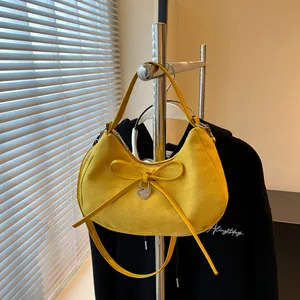 Sac hobo chic en daim jaune avec un nœud et un pendentif coeur en argent élégant