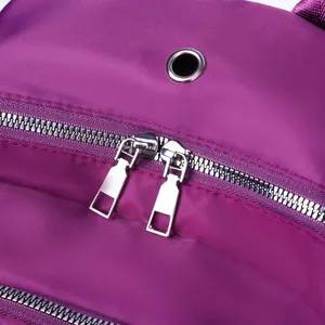 Detail van paarse nylon stof met metalen dubbele ritsen en versterkt metalen oogje