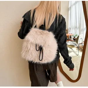 Detail view of the soft faux fur texture and black drawstrings on this apricot plush backpack