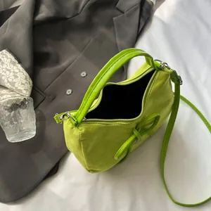 Sac fourre-tout vert fluo avec détail de noeud et bandoulière sur blazer gris