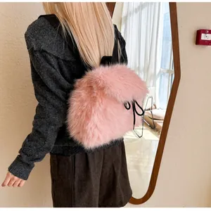 Rear view of a model wearing a soft pink faux fur backpack with black drawstring accents