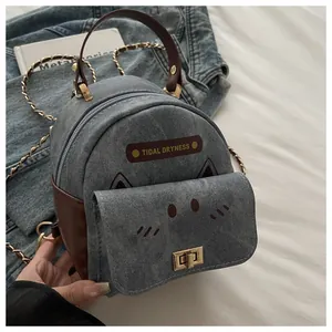 Detail of denim mini backpack with cat embroidery and golden twist lock closure