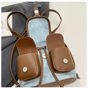 Détail du sac à dos en denim bleu et cuir marron avec poches avant aimantées et cordons