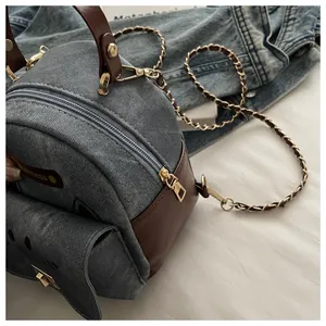 Detail of denim and brown leather patchwork bag with chain strap and cat whisker print