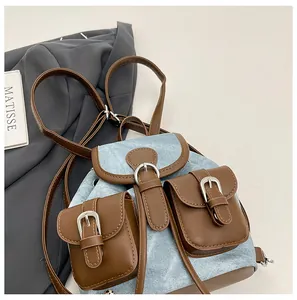 Détail d'un mini sac à dos en denim vintage avec bordure en similicuir et boucle métal