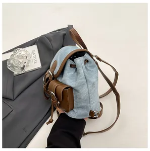 Détail d'un mini sac à dos en jean avec bordure en cuir et fermeture à cordon