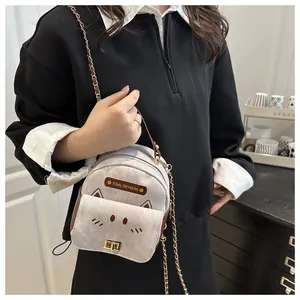 Close-up of small chain bag with cat face embroidery and brown leather trim detailing