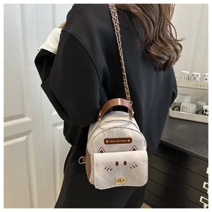 Detail of mini cat-shaped backpack with grey suede fabric and brown leather accents
