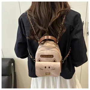 Detail of a pink cat-ear backpack featuring metal chain straps and turn-lock closure