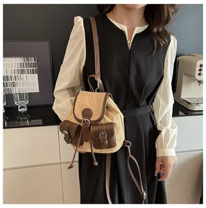Détail d'un sac à dos vintage en toile et cuir avec fermeture à cordon et poches