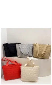 Quilted tote bags in black, gray, khaki, red, and beige on white display steps