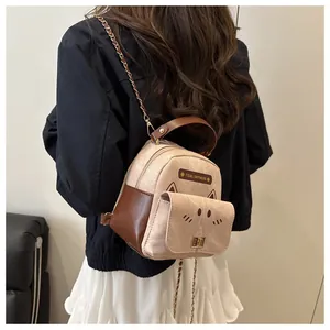 Detail of cute cat-themed mini backpack with gold chain strap and metal lock closure