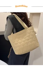 Detail of wavy quilted stitching on lightweight beige puffer tote bag with ribbon handles