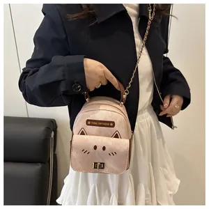 Mini pink crossbody backpack with cat face design and gold chain strap on model