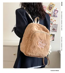 Close-up of brown plush backpack featuring pink heart embroidery and soft textile straps