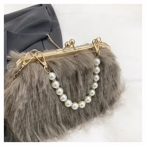 Dettaglio ravvicinato della borsa da sera in peluche con manico di perle e catena d'oro