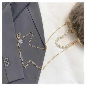 Dettaglio borsa a tracolla in peluche con chiusura dorata vintage e catena di perle