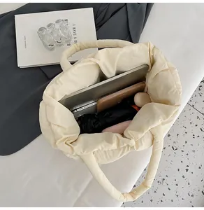 Spacious interior of beige quilted puffer tote bag filled with laptop and daily essentials