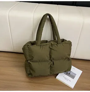 Close-up of olive green quilted puffer tote bag with glossy finish and square patterns