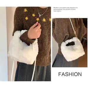 Detail view of white faux fur handbag with ruched handle and decorative brand tag