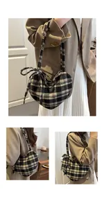 Detail der herzförmigen Plaid-Tasche mit seitlicher Schleife und Tweed-Textur