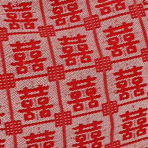 Close-up of red jacquard fabric with white traditional Xi pattern for bridal tote bag